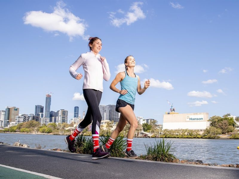 Two women running in Kidney Health red socks