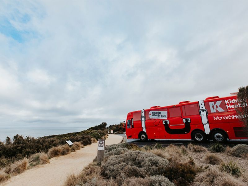 The big red kidney bus parked on the side of a road