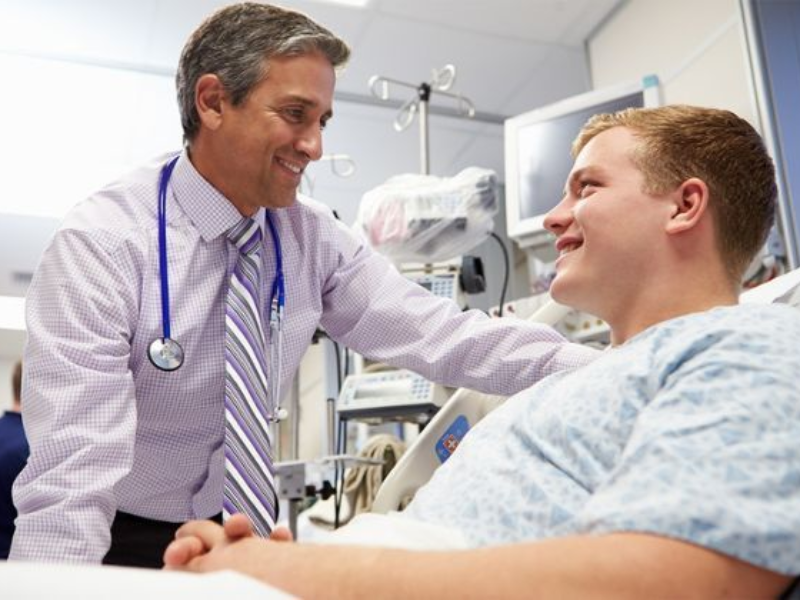 A male health professional consults with a young male patient