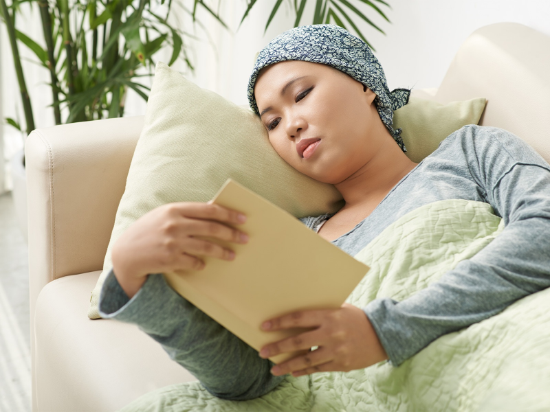 A woman reads a book on her couch