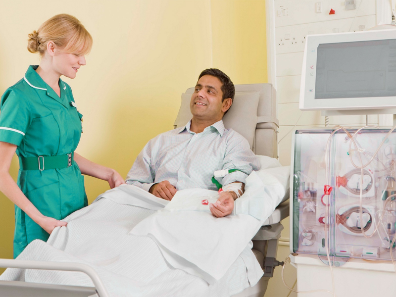A health professional consults with a man on dialysis