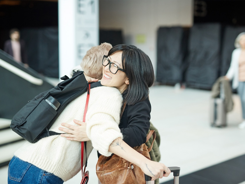 Two people embrace at an airport
