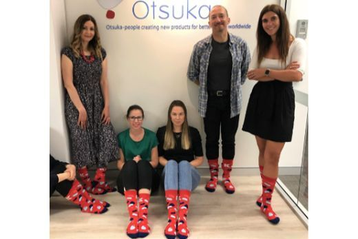 Otsuka staff pose for a photo in red socks