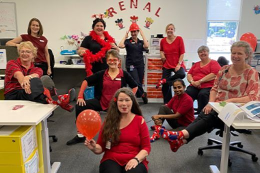 Employees pose for a photo while wearing red socks