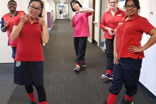 People posing for a photo in a hallway while wearing red socks