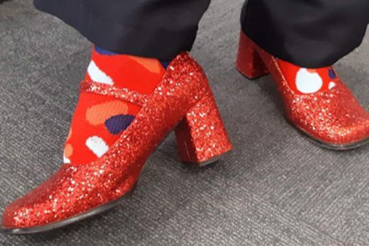 A woman poses in red shoes with kidney health australia red socks
