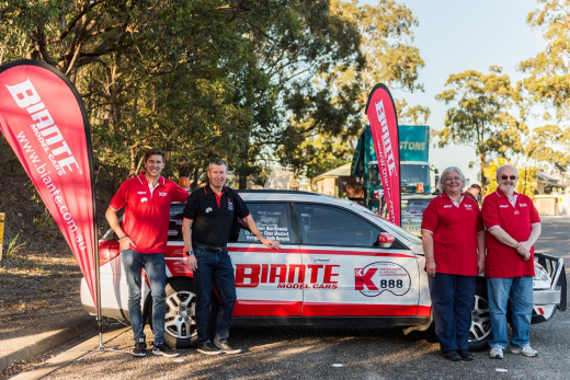 Drivers and owners of a Kidney Kar Rally car pose by the car