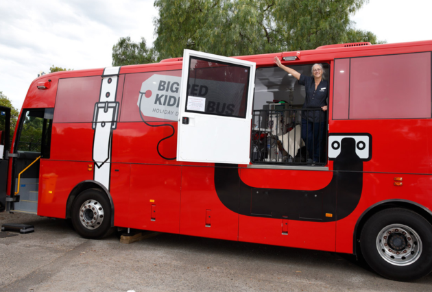The big red kidney bus with a health professional posing for a photo inside