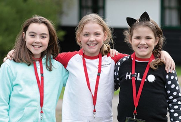 Three young girls wearing kidney health laniards