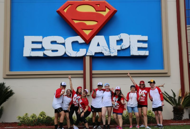 A group of kids pose for a photo in front of the Escape sign