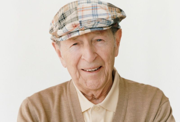 Old gentleman with tartan hat smiling.