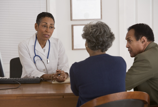 A female health professional consults with a couple