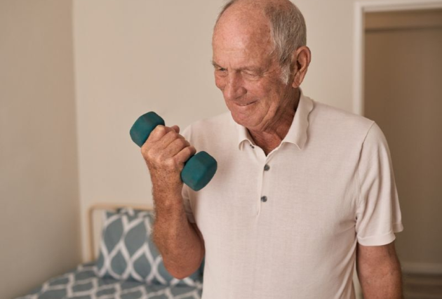 An older man exercises with dumbbells