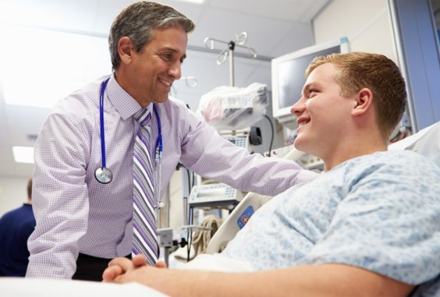 A male health professional consults with a young male patient