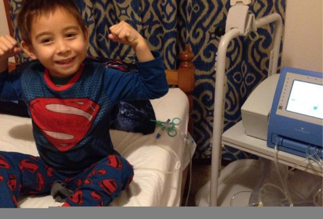 A young boy on dialysis poses as Superman