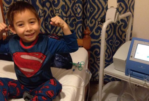A young boy on dialysis poses as Superman