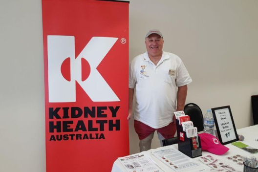 A man poses by a Kidney Health Australia event banner