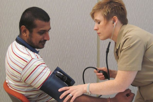 A health professional measures a man's blood pressure