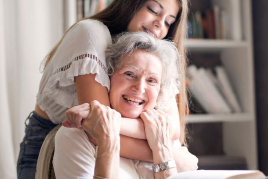 Young woman hugging smiling older woman