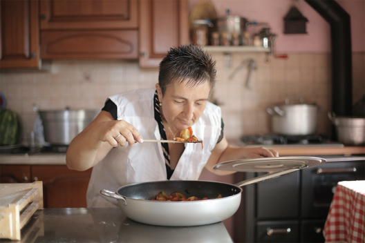 A woman eats food from a pan