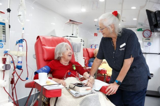 A health professional talks to an older woman on dialysis